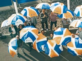 Recognition Express bosses celebrate the rebrand with umbrellas bearing the new logo