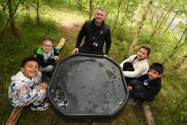 Scott Beardsworth, outdoor learning teacher and head of PE, with pupils in the forest school area for outdoor learning.