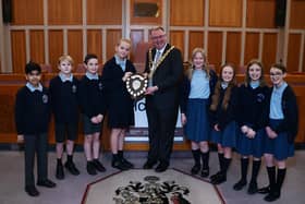 Mayor of Wigan Coun Kevin Anderson presents the trophy to pupils from St Wilfrid's C of E Primary Academy, Standish, with runners-up from St Mary and St John's RC Primary School, right