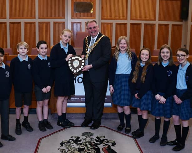 Mayor of Wigan Coun Kevin Anderson presents the trophy to pupils from St Wilfrid's C of E Primary Academy, Standish, with runners-up from St Mary and St John's RC Primary School, right
