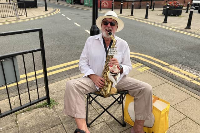Spud the saxophone player sitting in Atherton high street