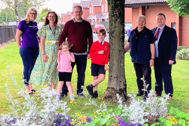 Staff and pupils at the colourful flower beds at Aspull Church Primary School with Con Ron Conway, second from right