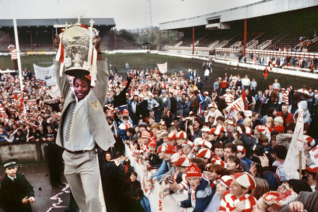 Wigan winger Henderson Gill precariously balanced on the wall of the players tunnel at Central Park shows the Challenge Cup to fans at the homecoming on Sunday 5th of May 1985 after Wigan had beaten Hull in the final on the previous day at Wembley.