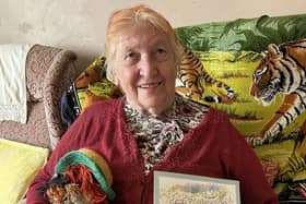 Barbara Anderton with the book written by her husband John Anderton
