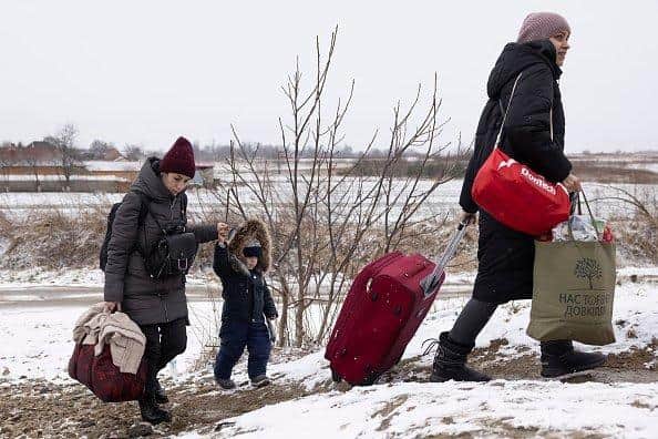 Refugees fleeing conflict make their way to the Krakovets border crossing with Poland