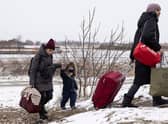 Refugees fleeing conflict make their way to the Krakovets border crossing with Poland