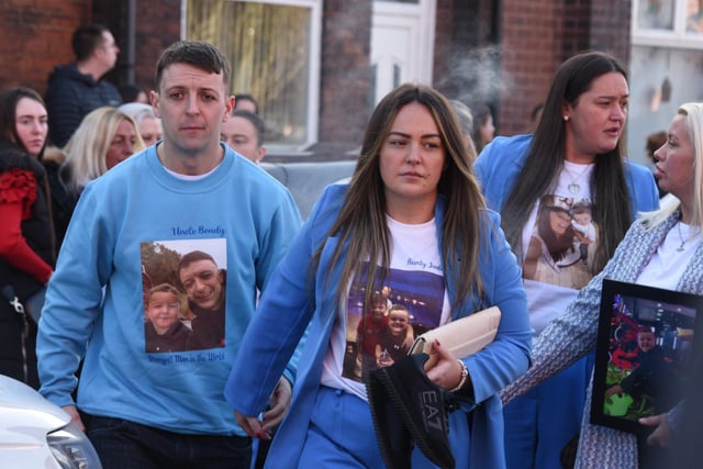 Relatives dressed in blue and wore clothes with photographs of Theo