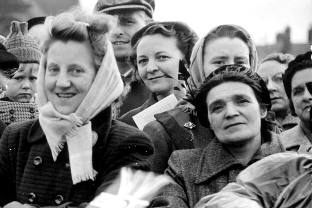 These happy people are obviously expected a royal visitor. It's the new Queen Elizabeth who paid her first royal visit to the town just a year after her coronation. The photo was taken at the bottom of Market Street, Wigan.