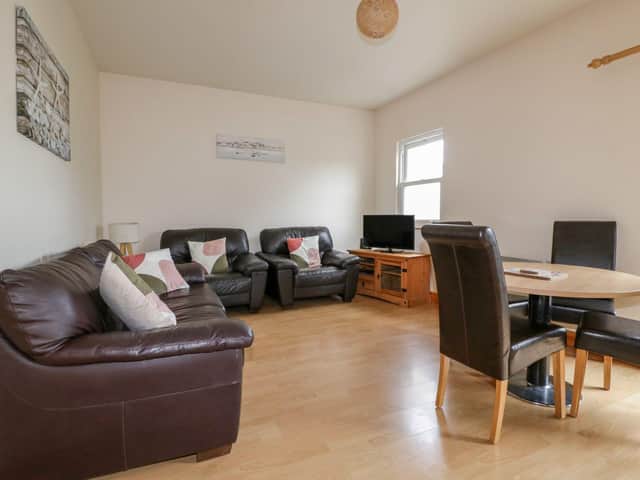 The open-plan living area at 13 Palm View, Newquay. Available to book through Sykes Cottages.
