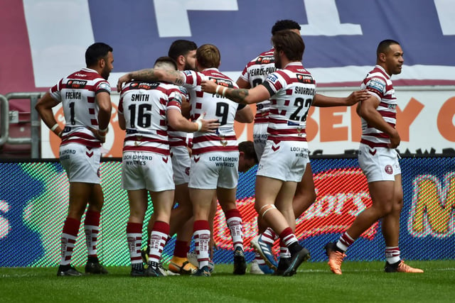 The Wigan players celebrate after Abbas Miski goes over for the first try of the night.