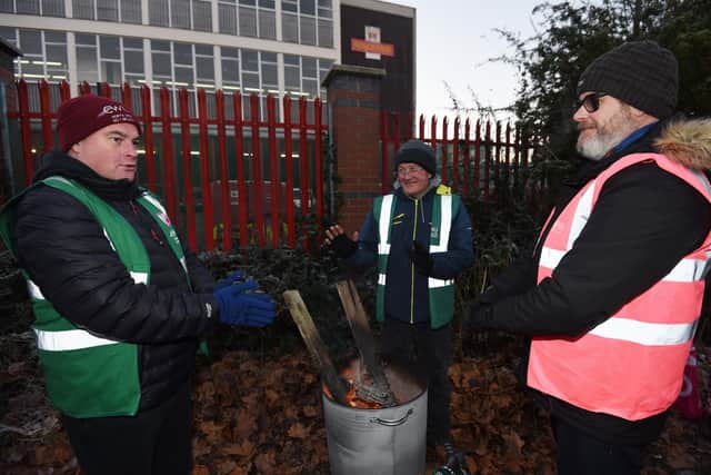 Workers try to keep warm on the picket line