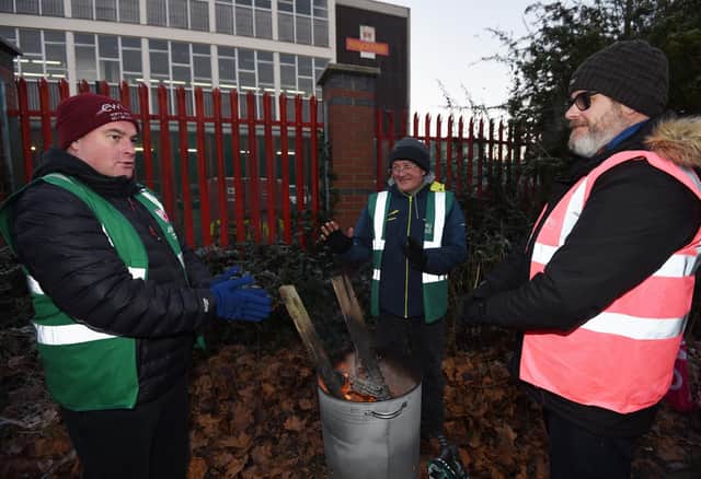 Workers try to keep warm on the picket line