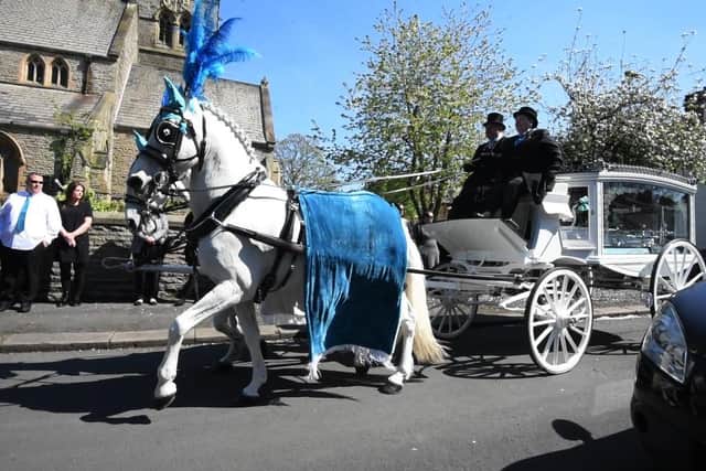 A horse-drawn carriage arrives at St Peter's Church for the funeral