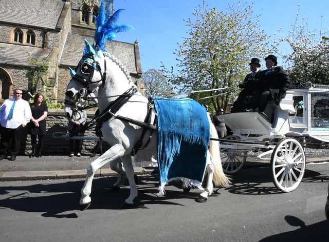 A horse-drawn carriage arrives at St Peter's Church for the funeral