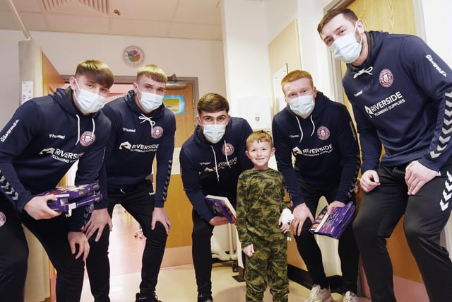 A young rugby fan meets Wigan Warriors players at the Rainbow children's ward at Wigan Infirmary.