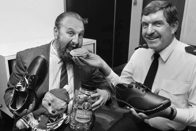 Greater Manchester Chief Constable James Anderton getting his teeth into a Poole's pie as he receives various traditional Wigan souvenirs from the then Divisional Commander, Chief Superintendent Gordon Burton, during a special lunch at Wigan police headquarters for the Wigan born top cop to celebrate his knighthood on Tuesday February 19 1991.