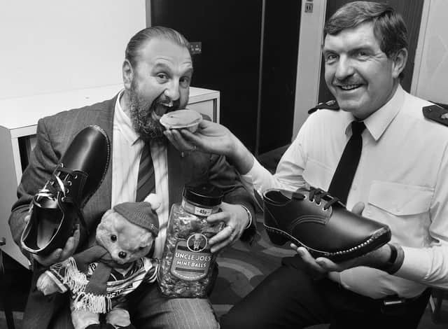 Greater Manchester Chief Constable James Anderton getting his teeth into a Poole's pie as he receives various traditional Wigan souvenirs from the then Divisional Commander, Chief Superintendent Gordon Burton, during a special lunch at Wigan police headquarters for the Wigan born top cop to celebrate his knighthood on Tuesday February 19 1991.
