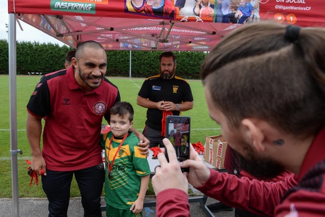 A young fan has a photo with Thomas Leuluai.