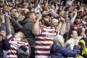 Wigan fans celebrate the victory over St Helens