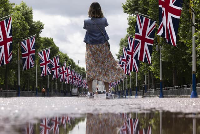 A member of the public takes a photograph on the Mall lined with Union Flags