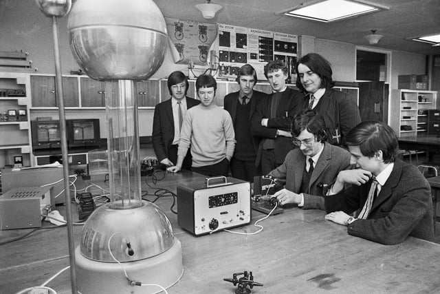 Sixth form pupils Michael McCaul and Martin Cassian (seated) in the science laboratory working on an experiment to find magnetic deflection of Beta P particles watched by other pupils at Blessed John Rigby Grammar School, Orrell, in May 1971.