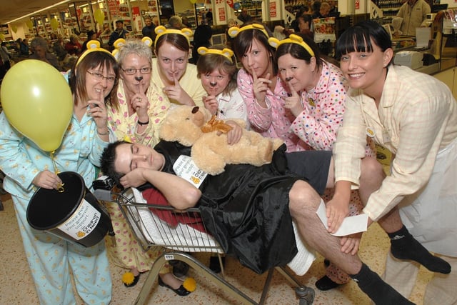 Anthony Longshaw about to get a rude awakening at the Children In Need pyjama party at Morrisons in Wigan town centre as Claire Eccles gets ready to wax his legs.