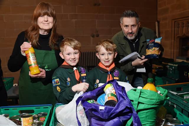 Cub Scouts Josh and Oliver Seddon, seven, with food bank volunteer Christine Barnes and food bank project manager Warren Done