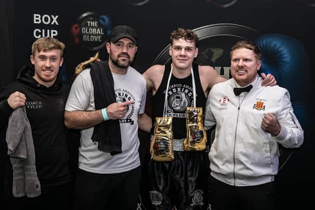 Aydin Uzsoy (second from right) celebrates his win with (from left to right) coaches Tyler Owen and Rick Golding, along with Alan Smith