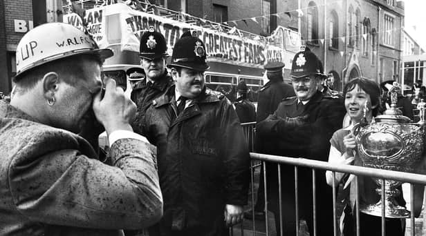 Wigan hooker Nicky Kiss obliges a young fan by taking his picture with the Challenge Cup as the team bus arrives at Wigan town hall for a civic reception on Sunday 1st of May 1988 after their Wembley triumph. 