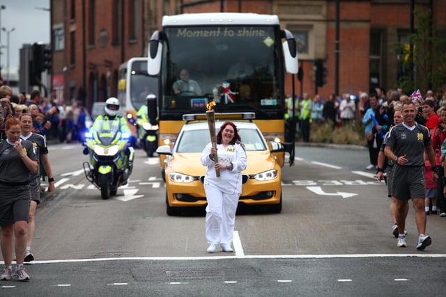 Torchbearer 102 Hazel Johnson carries the Olympic Flame on the Torch Relay leg between Wigan and Ince-in-Makerfield.