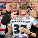 Josh Cartwright embraces his family after making his Wigan Warriors debut