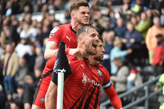 Charlie Wyke is mobbed by Tom Pearce after opening the scoring at Derby