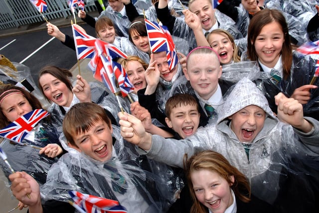 Pupils of Pembec High School wait in the rain for the Queen and Prince Philip to arrive at Heinz.