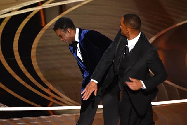 Will Smith (R) slaps US actor Chris Rock onstage during the 94th Oscars at the Dolby Theatre in Hollywood