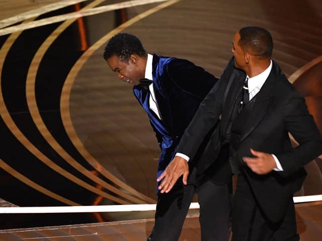 Will Smith (R) slaps US actor Chris Rock onstage during the 94th Oscars at the Dolby Theatre in Hollywood