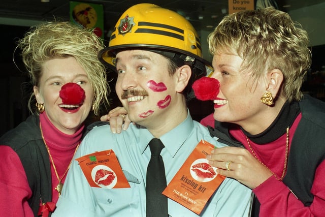 Fireman Dave Waite is plastered with kisses by Bodyshop, Wigan, manageress, Coralie Jackson-Smailes, and deputy, Kay Crosby, who were selling kissing kits on Red Nose day in aid of Comic Relief in 1997.