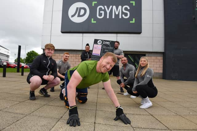 Nigel Brookwell  on all fours with staff from JD Gym, Wigan, showing their support,  from left, Matthew Peacock, Lewis Bolton, Alysha Berrigan, Liam Hill, Tony Tomlinson and Sam Heaton.