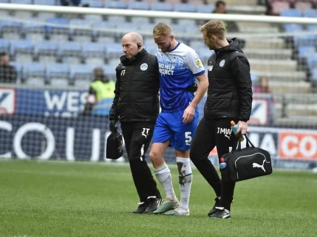 Jack Whatmough is helped from the field after damaging a knee against Norwich