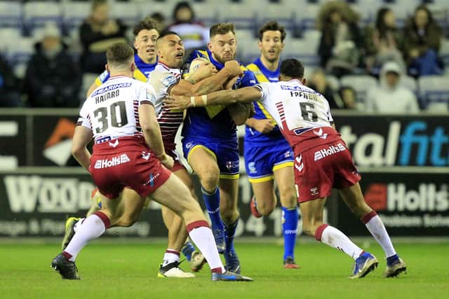 Wigan's Willie Isa and Bevan French  tackle Warringtons Daryl Clark in the opening game in 2020