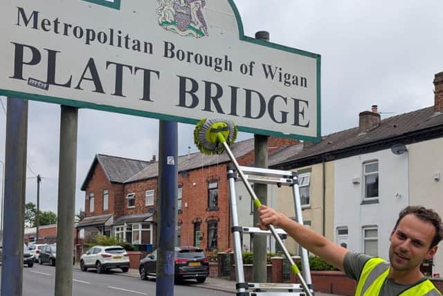 Josh in Platt Bridge recently, cleaning the town sign