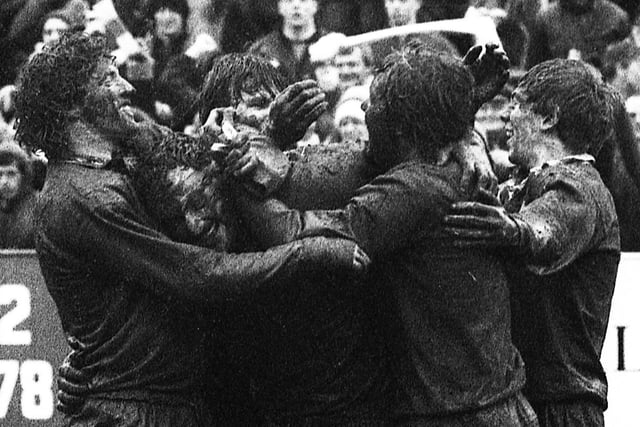 Mud caked Wigan players celebrate after beating St. Helens 16-7 in the Challenge Cup quarter-final at Knowsley Road on Sunday 11th of March 1984.