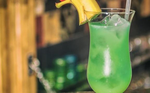 Ingredients: 45ml Vodka, 30ml Peach Schnapps, 15ml Blue Curacao, 60ml Pineapple Juice, 60ml Orange Juice, Splash of Soda Water, Garnish: Banana Wedge, Cherry. Method: Shake all ingredients with ice except the soda water, strain mix into an ice filled glass, add a splash of soda water, garnish with pineapple and a cherry.