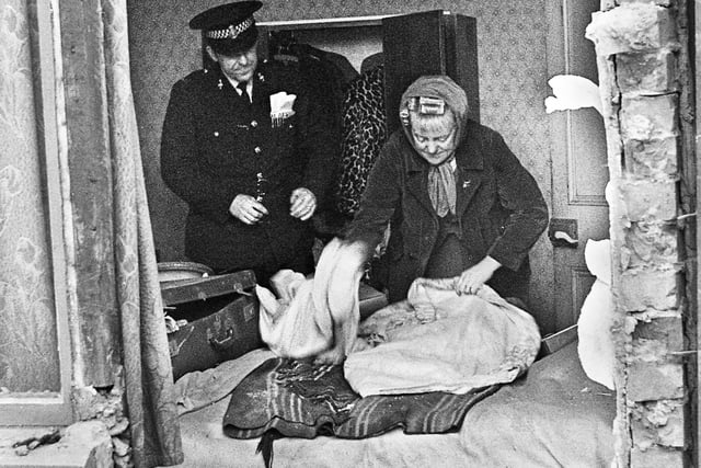 Florence Gavaghan rescues some bedding and clothing from her house in Spring Street, Wigan, after a gas explosion blasted the walls out on Tuesday 11th of April 1972. She had escaped with bruising after calling gas board official William Farrimond when she smelled gas. The two had a lucky escape.