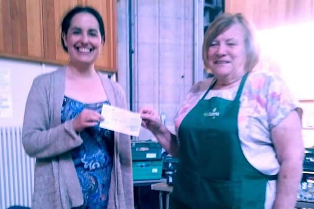 Kate Nixon presenting cheque to Trussell Trust's food bank in Atherton