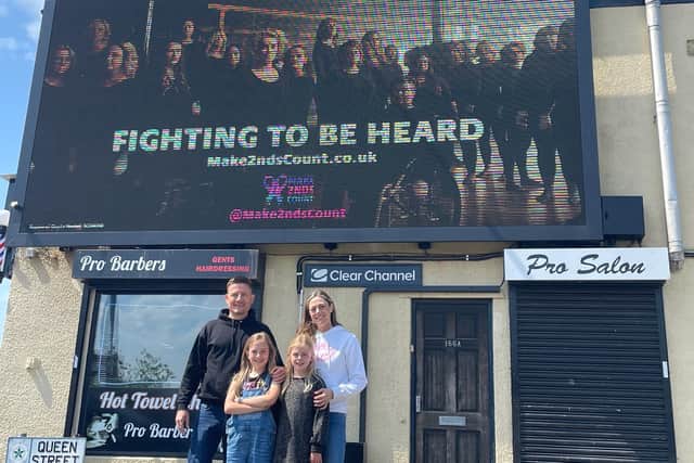 The family in front of the Salford billboard