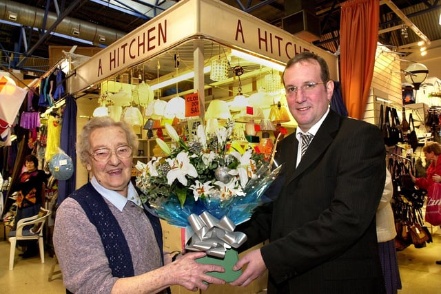 One of Wigan market's longest serving stallholders, Alice Hitchen, is presented with a bouquet by markets manager Philip Edge on her retirement on Wednesday 22nd of December 2004. Alice had run her lamp and electrical goods stall for 40 years in the old and new market halls.