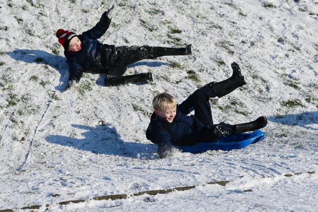 Wigan snow scenes - People make the most of the winter weather as snow falls on Mesnes Park, Wigan.