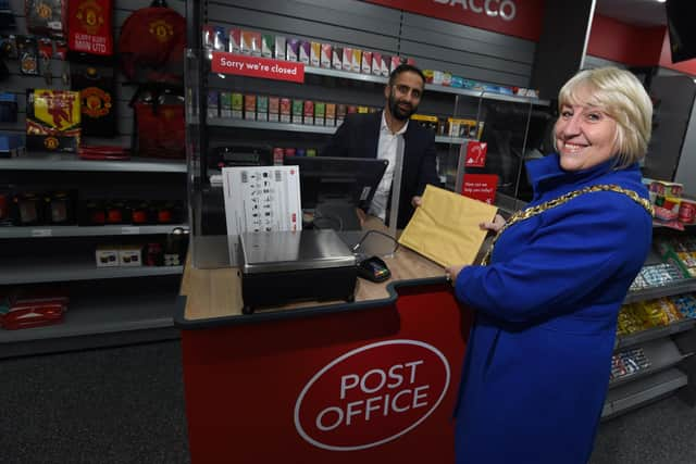 The Mayor of Wigan Coun Marie Morgan, right, is the first customer at the new Wigan Post Office, pictured with postmaster Arif Matadar