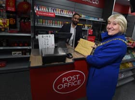 The Mayor of Wigan Coun Marie Morgan, right, is the first customer at the new Wigan Post Office, pictured with postmaster Arif Matadar