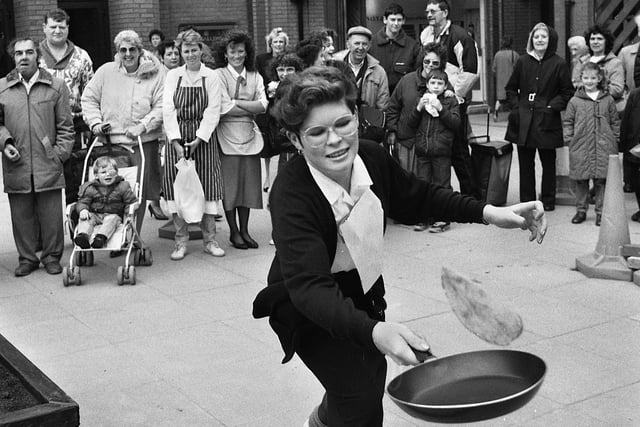 A Wigan market worker taking part in a pancake race on Shrove Tuesday 7th of February 1989.